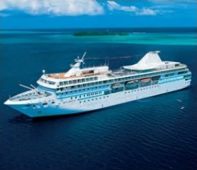 Das Kreuzfahrtschiff M/S Paul Gauguin aus der Luft auf einer blauen Lagune.