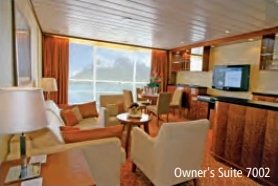 Salon der Owner’s Suite 7002 mit Sofas, Sesseln und grosser Fensterfront.