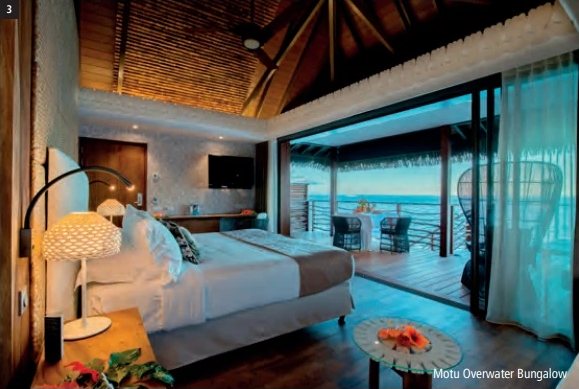 Innenansicht eines Motu Overwater Bungalows im InterContinental Tahiti Resort & Spa mit Bett, Holzdach und offener Terrasse zur Lagune.