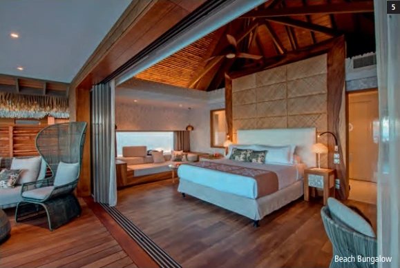 Innenansicht eines Beach Bungalows mit grossem Bett, Holzdecke und Parkettboden.
